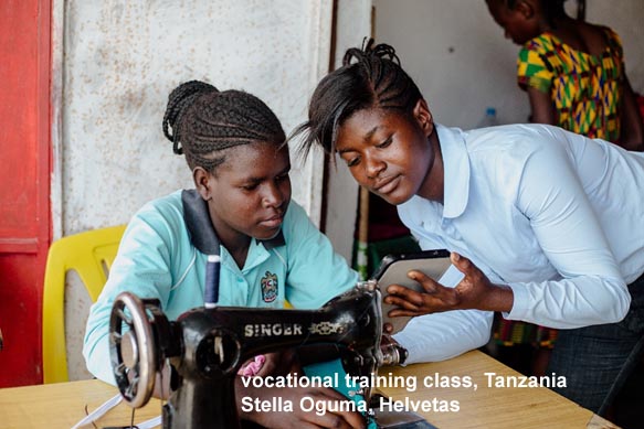 Tanzanian class - teacher and student at sewing machine (Helvetas)